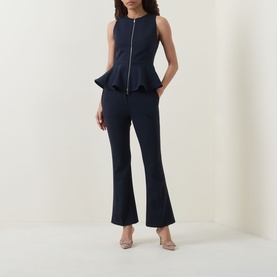 Model wearing Hugo Boss Talia-Crop1 Mid-Rise Flared Trousers in dark blue with pressed creases, styled with a matching navy peplum top and nude heels.