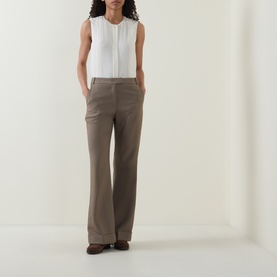 Model wearing Hugo Boss Brown Overflow wide-leg trousers in viscose blend, styled with a white sleeveless top and brown loafers.