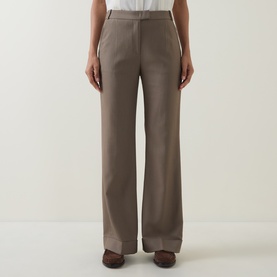 Model wearing Hugo Boss Brown Overflow wide-leg trousers with subtle front seam detail, styled with a white top and brown shoes.