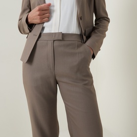 Model wearing Hugo Boss Brown Overflow trousers with matching blazer and white top; straight-leg silhouette with front crease detail.