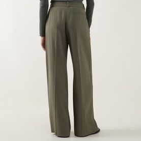 Model wearing Hugo Boss wide-leg trousers in khaki, rear view, high-rise waist with pleat detail, styled with a grey long-sleeve top.
