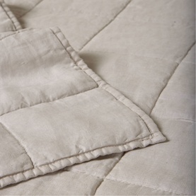 Foxford quilted blanket in natural oatmeal tone, close-up showing stitched diamond pattern and neatly finished edge detail