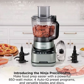 Ninja PrecisionPro Food Processor in silver with blades, discs, and accessories displayed on a kitchen worktop