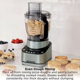 Ninja PrecisionPro Food Processor in silver, shown mixing dough with bread and pastries styled around it on a marble surface.