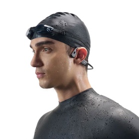 Model wearing Shokz OpenSwim Pro Wireless Headphones in grey, styled with black swim cap and goggles and wetsuit.