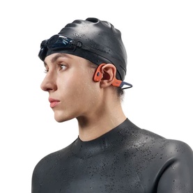 Model wearing Shokz OpenSwim Pro Wireless Headphones in Red, styled with black swim cap, goggles and wetsuit.