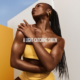 Model with glowing, luminous skin in a yellow bandeau top, illustrating Sol De Janeiro body lotion light-catching sheen finish