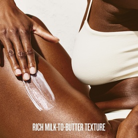 Sol De Janeiro body cream applied to skin, showing rich milk-to-butter texture as model smooths product onto leg
