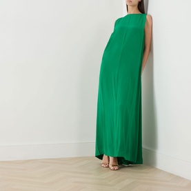 Model wearing Staud kelly green silk maxi dress with sleeveless design and relaxed silhouette, styled with strappy sandals