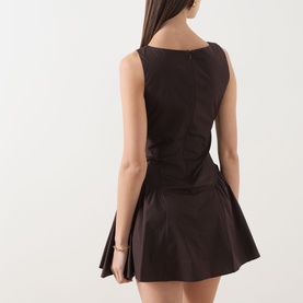 Model wearing Staud dress in Earth, rear view showing sleeveless fit-and-flare silhouette with structured skirt and centre back seam detail.