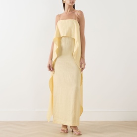 Model wearing Staud Valencia Ruffle Dress in butter yellow, maxi length column silhouette with spaghetti straps and draped ruffle detail