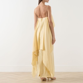 Model wearing Staud Valencia Ruffle Dress in Butter, backless maxi with spaghetti straps and draped ruffle detail in lightweight linen.