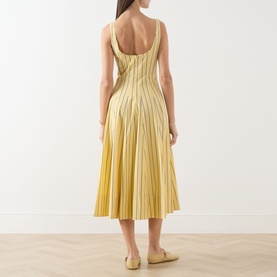 Model wearing Staud dress in Monday Stripe, back view, pleated midi skirt, scoop back, styled with beige flat shoes