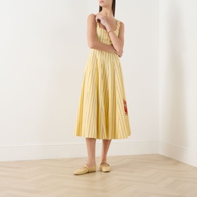 Model wearing Staud dress in Monday Stripe Lobster, yellow striped midi with pleated skirt and lobster detail, styled with yellow mules