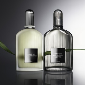 Tom Ford Eau de Grey Vetiver EDT shown in two bottles: clear glass and smoky grey glass, with ribbed detailing and silver caps.