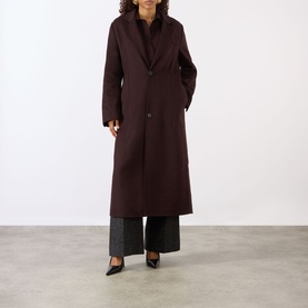 Model wearing Victoria Beckham Single-Breasted Coat in Acai, notched lapels, button fastening, maxi length, styled with grey wide-leg trousers and