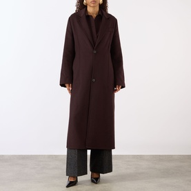 Model wearing Victoria Beckham Single-Breasted Coat in Acai, notched lapels, button fastening, maxi length, styled with wide-leg grey trousers