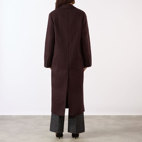 Model wearing Victoria Beckham Single-Breasted Coat in Acai, rear view showing back vent, with grey wide-leg trousers.