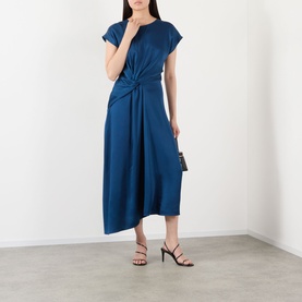 Model wearing Victoria Beckham Aria Twist Waist Dress in Dark Ocean with twist waist detail and asymmetric hem, styled with black heeled sandals and