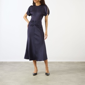 Model wearing Victoria Beckham Midnight dress with short tulip sleeves and ruched waist detail, styled with black ballet flats
