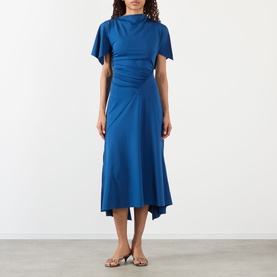 Model wearing Victoria Beckham Gathered Asymmetric Dress in Dark Ocean, styled with gold flat sandals