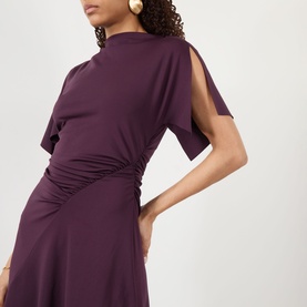 Model wearing Victoria Beckham Gathered Asymmetric Dress in Blackcurrent, showing gathered diagonal waistline, split sleeves and high neckline detail