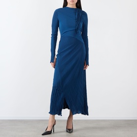 Model wearing blue long-sleeve midi dress with pleated skirt detail and side ruche, styled with black heels