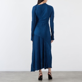 Model wearing a teal blue long-sleeve ribbed midi dress with asymmetric hem, styled with black heeled sandals, rear view