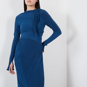 Model wearing teal blue long sleeve midi dress with ruched drape detail at shoulder and pleated skirt