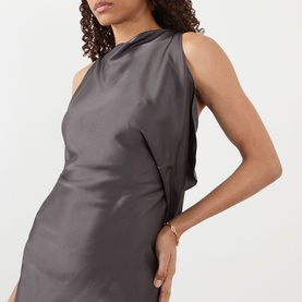 Model wearing Victoria Beckham Ore dress with sleeveless silhouette and high neck, styled with a gold bracelet