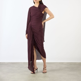 Model wearing Victoria Beckham Dress in Acai, ruched asymmetric one-shoulder maxi style with draped cape detail, paired with black strappy heels.