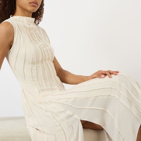 Model wearing Victoria Beckham Pleated Asymmetric Dress in Elderflower, featuring high neck, sleeveless silhouette and pleated detail