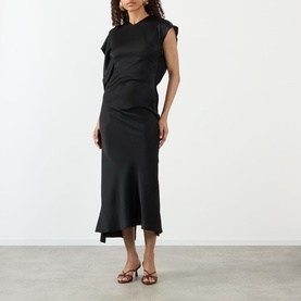Model wearing Victoria Beckham black sleeveless midi dress with draped bodice and asymmetric hem, styled with brown strappy sandals.