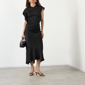 Model wearing Victoria Beckham black asymmetric midi dress with ruched detail, styled with a mini black bag and brown strappy heels