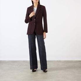 Model wearing Victoria Beckham Katherine Single-Breasted Blazer in Acai, styled with wide-leg dark denim jeans and black heels.