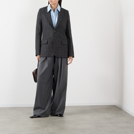 Model wearing Victoria Beckham Ore Melange blazer jacket, styled with wide-leg grey trousers, blue shirt, and black loafers