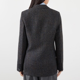 Model wearing Victoria Beckham Ore Melange jacket, rear view showing tailored fit, notched lapel and long sleeves in textured wool-blend fabric.