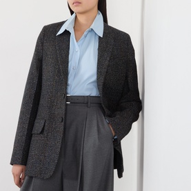 Model wearing Victoria Beckham Ore Melange jacket with light blue shirt and grey tailored trousers