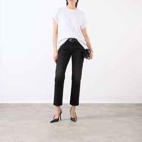 Model wearing Victoria Beckham Washed Black denim jeans, styled with a white t-shirt, black heels and small clutch bag.