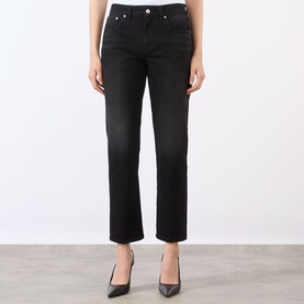 Model wearing Victoria Beckham Washed Black straight-leg jeans, styled with black pointed-toe heels.