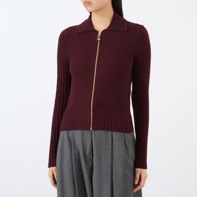 Model wearing Victoria Beckham Zip Knitted Polo Sweater in Acai, ribbed with gold-tone front zip, styled with grey wide-leg trousers