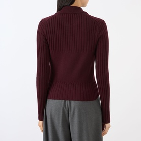 Model wearing Victoria Beckham Zip Knitted Polo Sweater in Acai, rib-knit construction, long sleeves, styled with grey wide-leg trousers. Rear view.