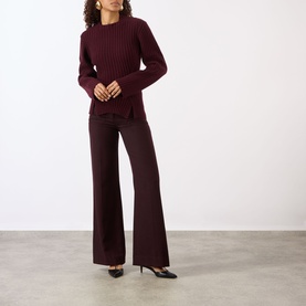 Model wearing burgundy ribbed knit jumper and matching wide-leg trousers, styled with black kitten heel shoes