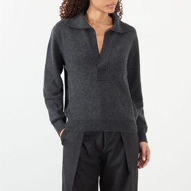 Model wearing Victoria Beckham Genevieve Knitted Polo Sweater in Ore Melange, with V-neckline and ribbed trims, styled with black wide-leg trousers.