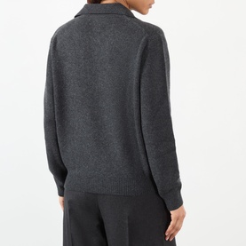 Model wearing Victoria Beckham Genevieve Knitted Polo Sweater in Ore Melange, back view, ribbed trims, styled with wide-leg trousers.