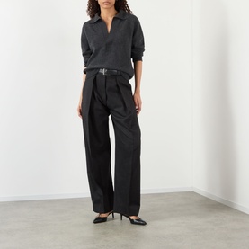 Model wearing Victoria Beckham Genevieve Knitted Polo Sweater in Ore Melange with wide-leg black trousers, belt and black heels.