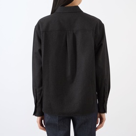 Model wearing black long-sleeve relaxed shirt, back view, styled with dark denim jeans