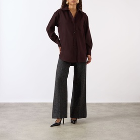 Model wearing Victoria Beckham Remi Patch Pocket Shirt in Acai, styled with grey wide-leg trousers and black heels