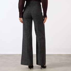 Model wearing Victoria Beckham Alina High-Rise Wide Leg Trousers in Ore Melange, styled with a dark burgundy top and black heels.