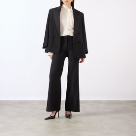 Model wearing Victoria Beckham black wide-leg trousers, styled with a cream blouse, black blazer and black pointed-toe heels.